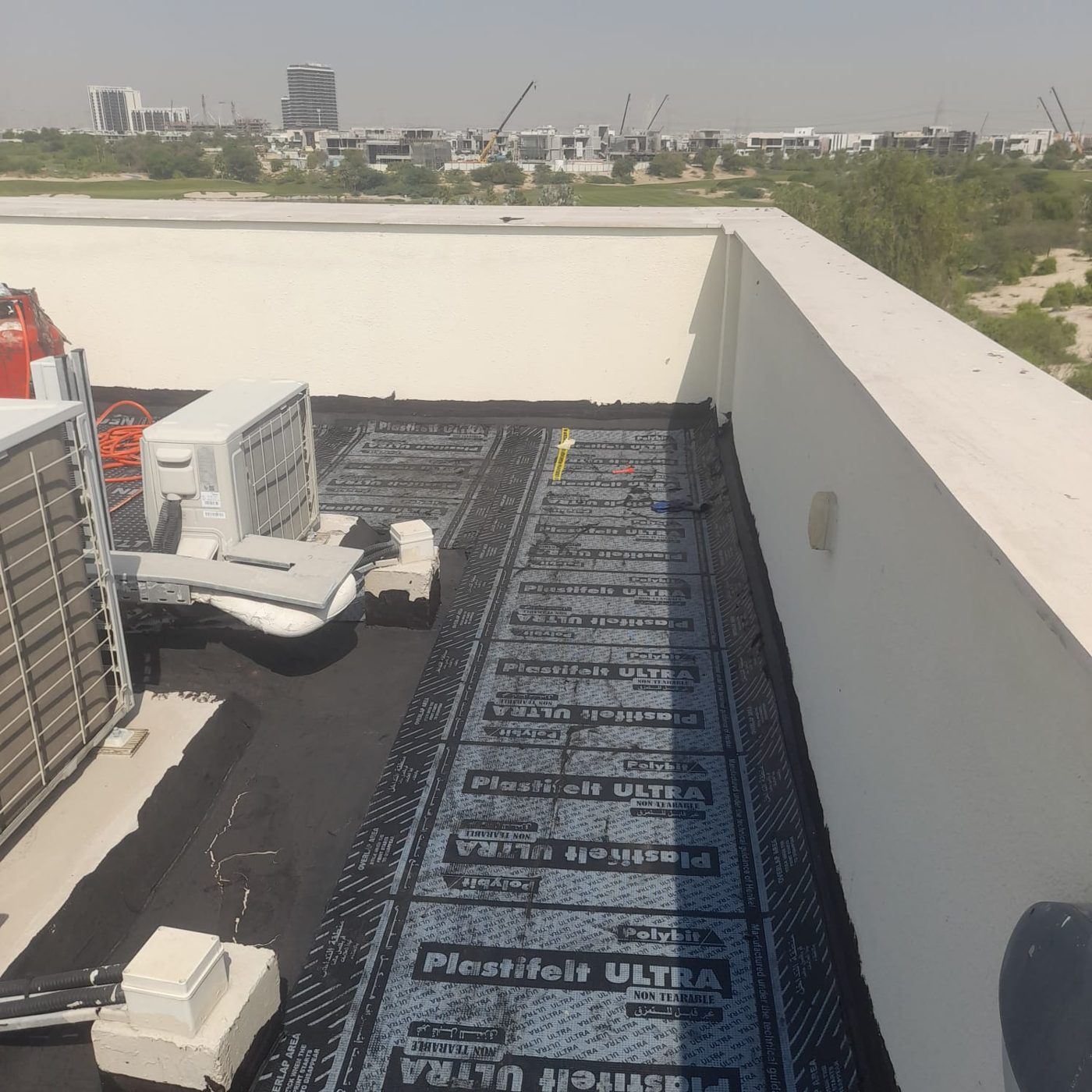 Waterproofing membrane installation at a Dubai villa parapet wall